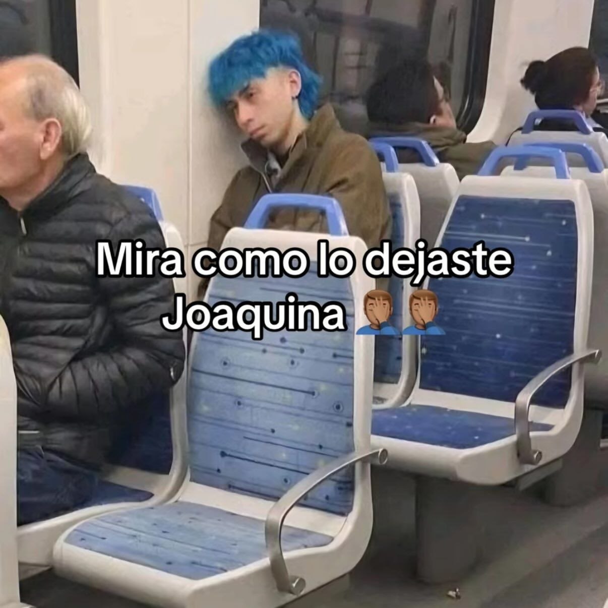 a man with blue hair sitting on a train